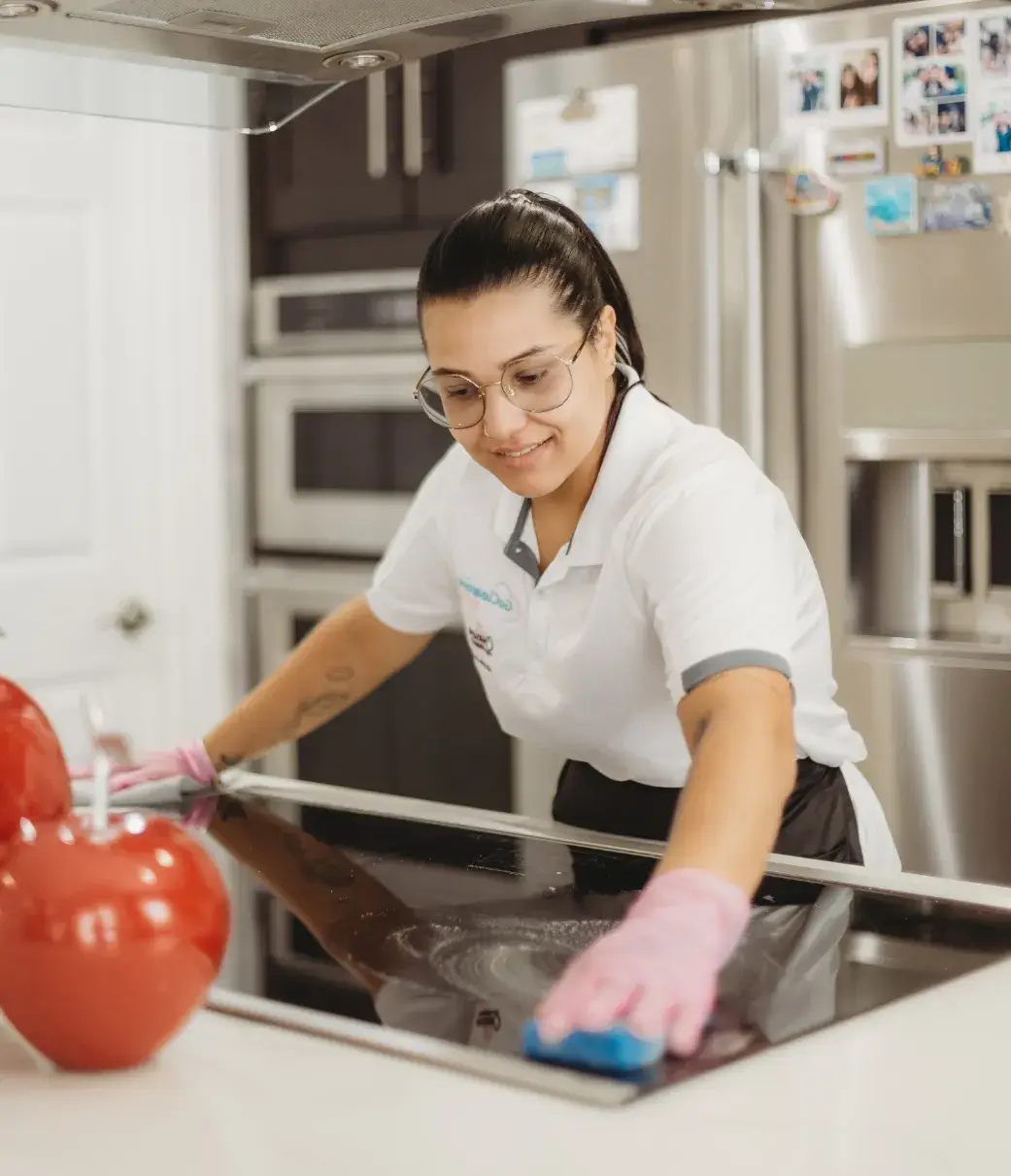 Go Cleaning Maids team member performing one-time stovetop cleaning in South Florida kitchen