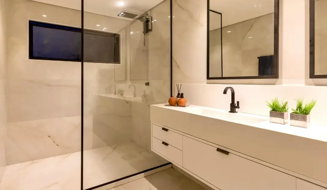 Modern bathroom with glass shower and clean white vanity.