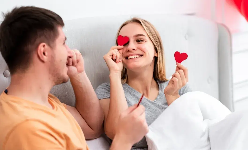Couple celebrating Valentine’s Day in a clean, cozy bedroom with heart decorations